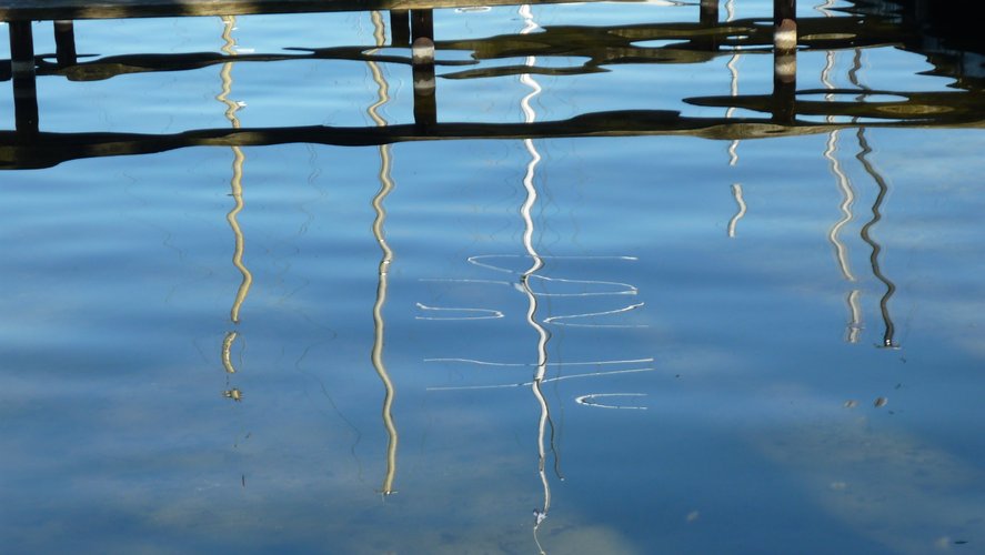 Spiegelung von Bootsmasten auf dem Wasser