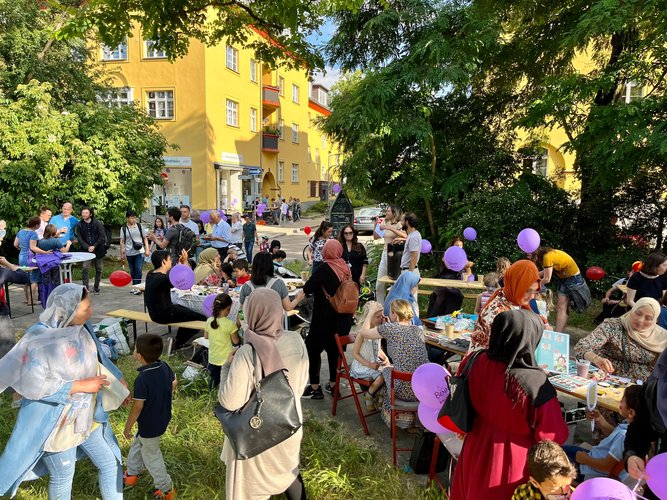 Menschen bei einem Picknick an Tischen im Park