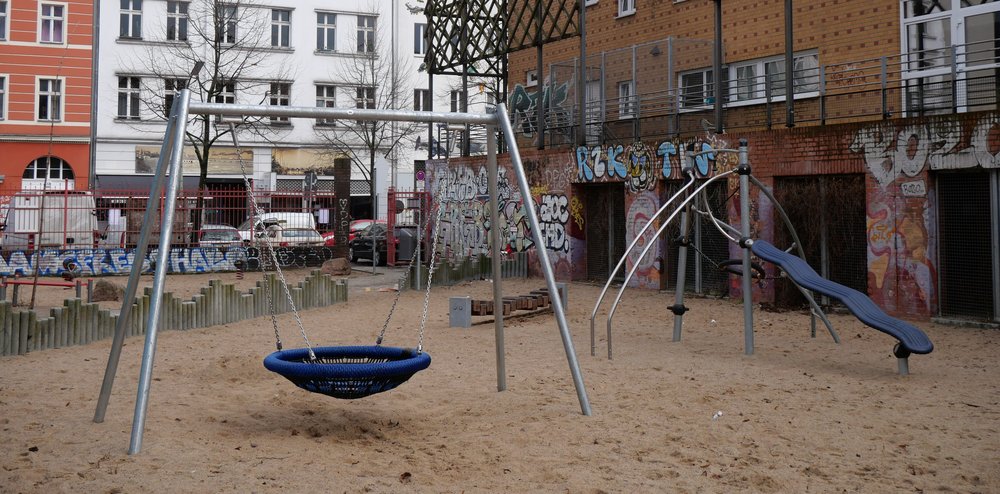 Der Spielplatz Dresdener Str. 127 mit Spielgeräten, Blick zur Straße.