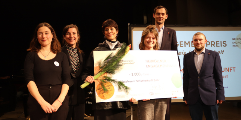 Geehrte Personen halten übergroßen Scheck in den Händen