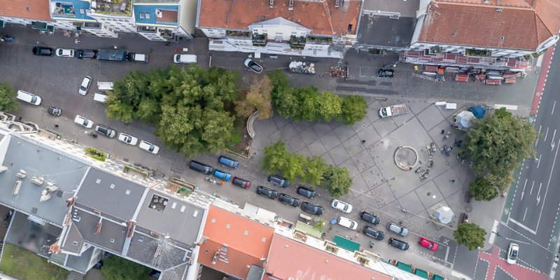 Luftbild von einem dreieckigen Platz der von Häusern umgeben ist