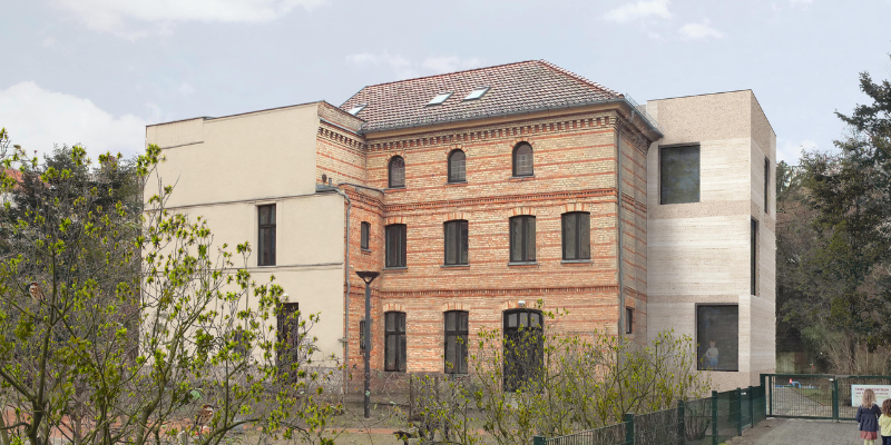 Gebäude mit Anbau, Bäume vorne, Frau mit Kindern links.