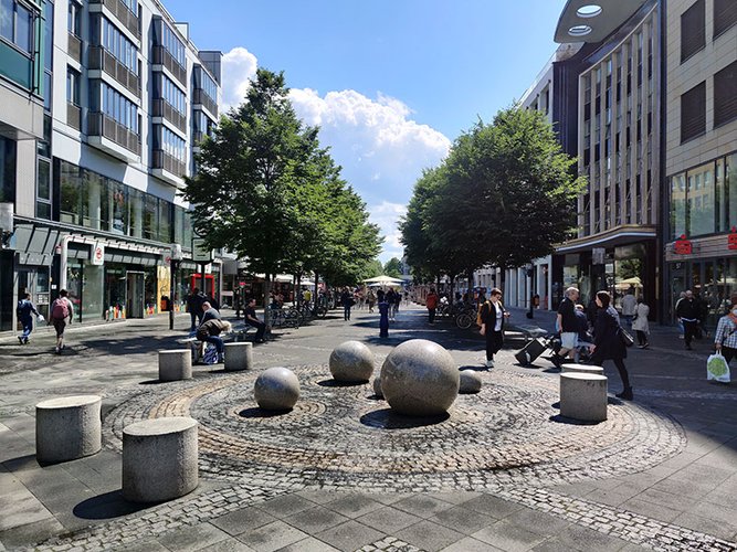 Die Wilmersdorfer Straße mit Menschen an einem sonnigen Tag.