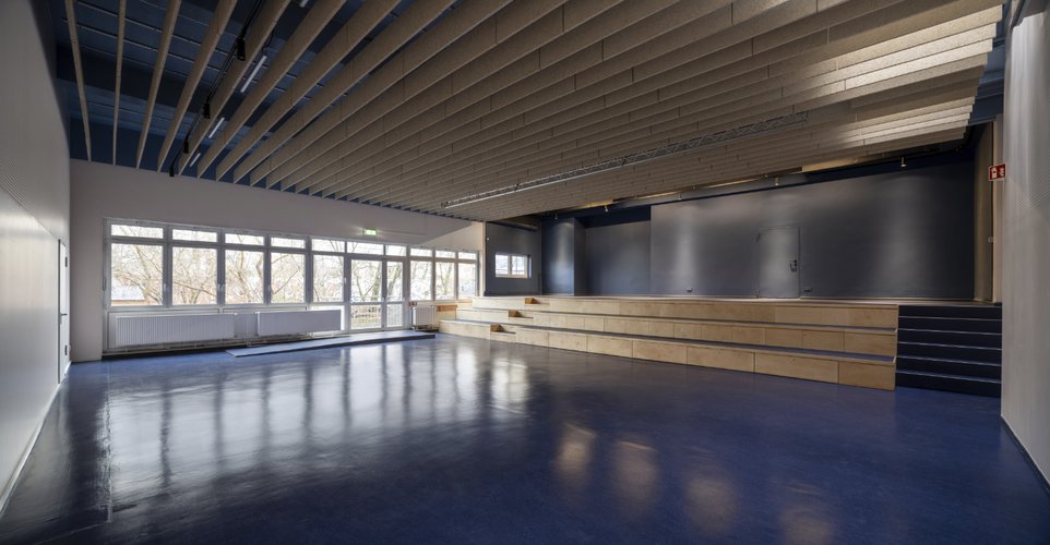 Der Saal der Freien Schule am Mauerpark mit der neuen Bühnen-Sitztreppe aus Holz