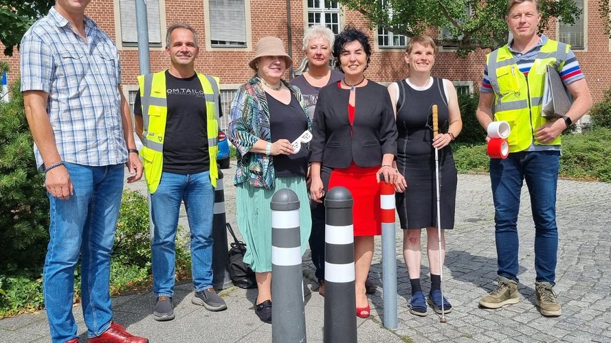 Gruppe von Menschen aus dem Bezirksamt Reinickendorf vor markierten Pollern