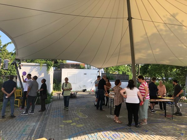 Menschen unter einer Überdachung bei einer Beteiligung