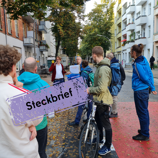 Menschengruppe versammelt sich auf der Straße und hört einer Präsentation zu