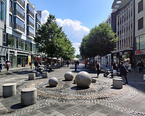 Die Wilmersdorfer Straße mit Menschen an einem sonnigen Tag.