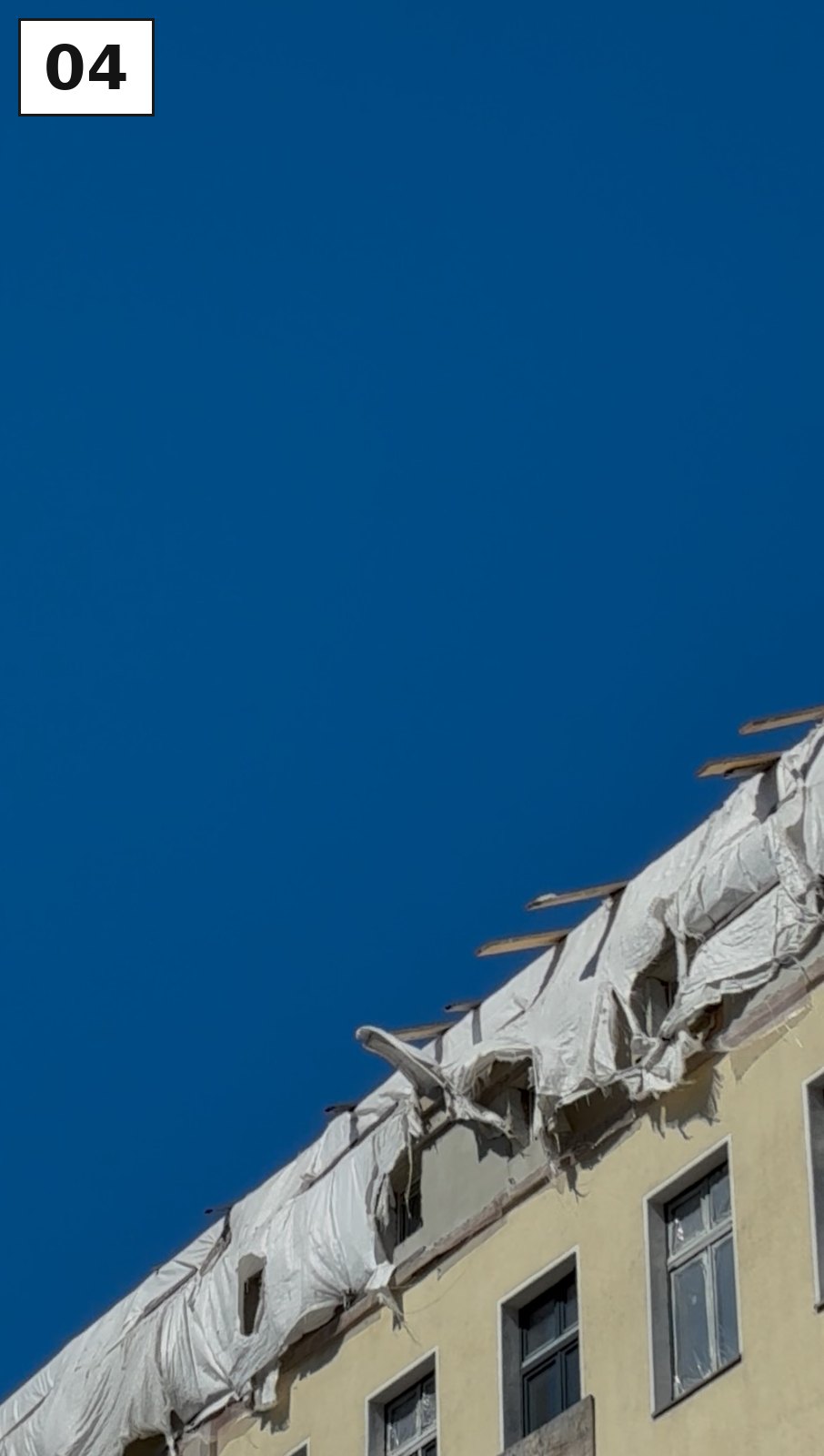 Häuserdach mit Balkonen vor tiefblauem Himmel