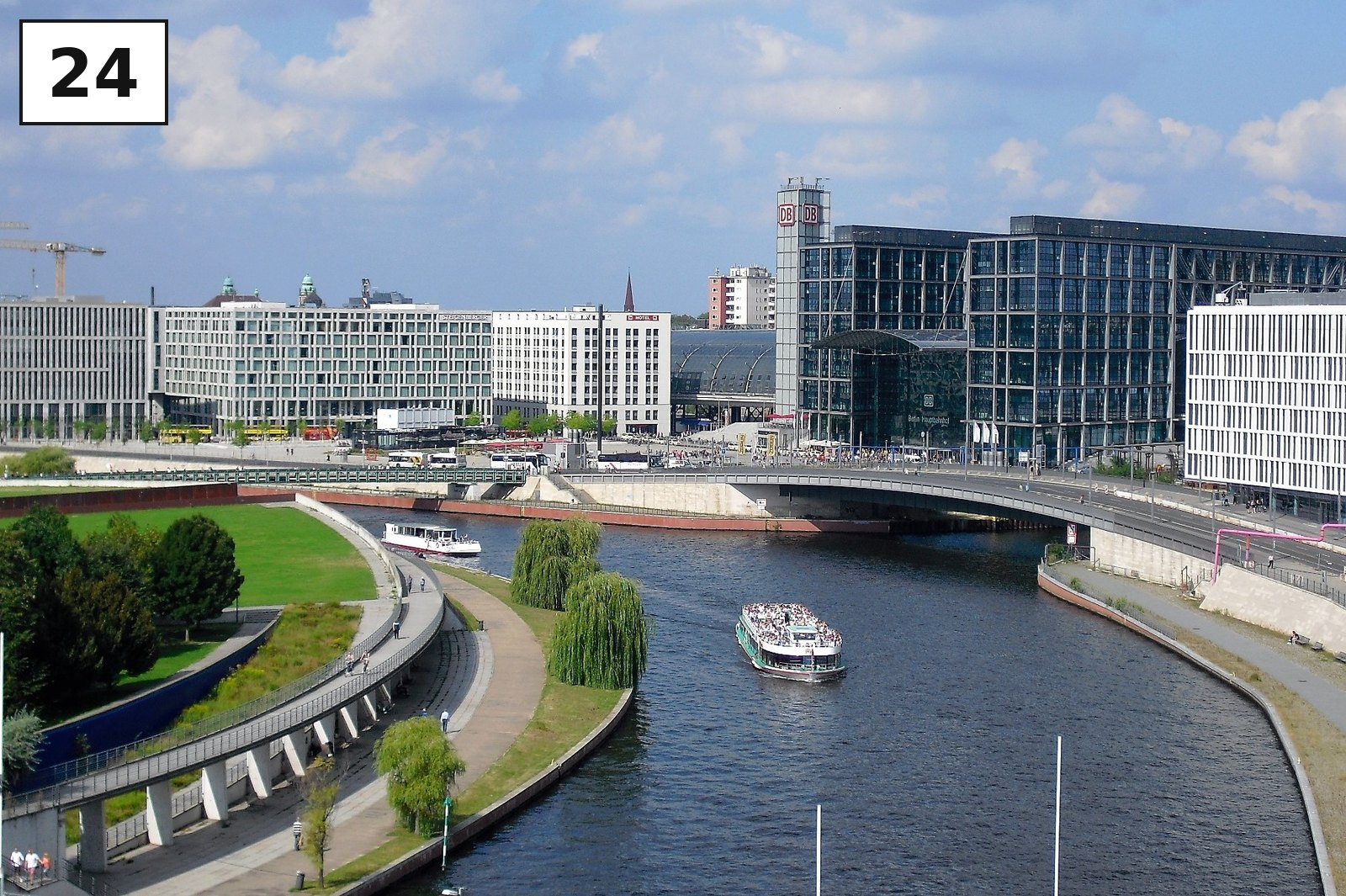 Hauptbahnhof und Bürogebäude an der Spree, ein Ausflugsschiff fährt vorbei